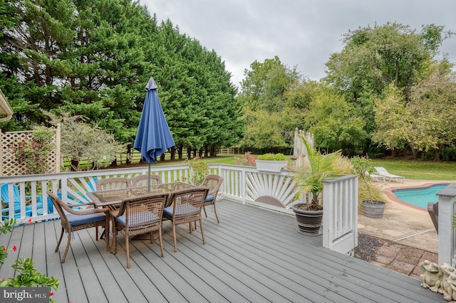 deck featuring outdoor dining space and an outdoor pool