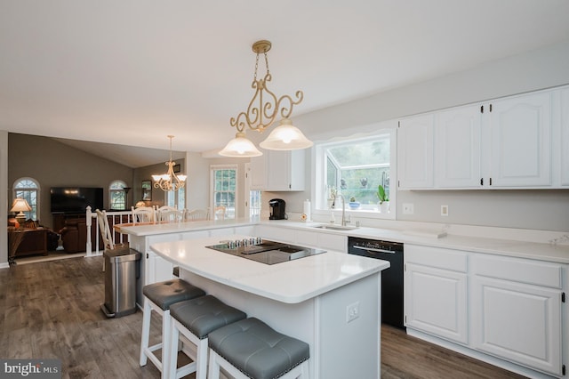 kitchen with dark wood-style floors, black appliances, a sink, and white cabinets