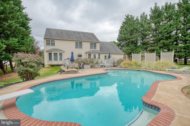 view of pool featuring a fenced in pool, fence, a wooden deck, and a diving board