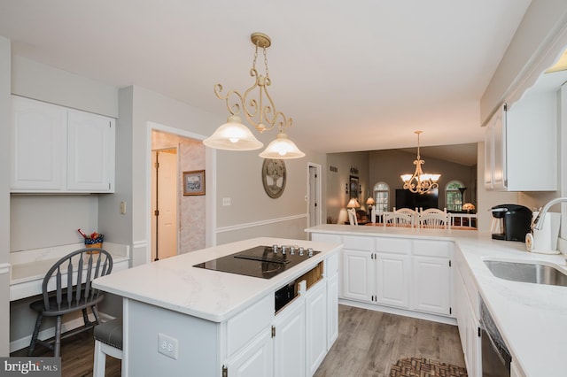 kitchen featuring vaulted ceiling, black electric stovetop, a sink, and light wood-style flooring