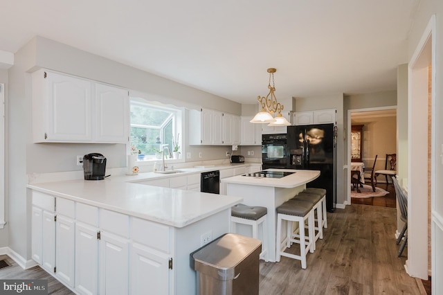 kitchen with white cabinetry, a sink, a peninsula, and black appliances