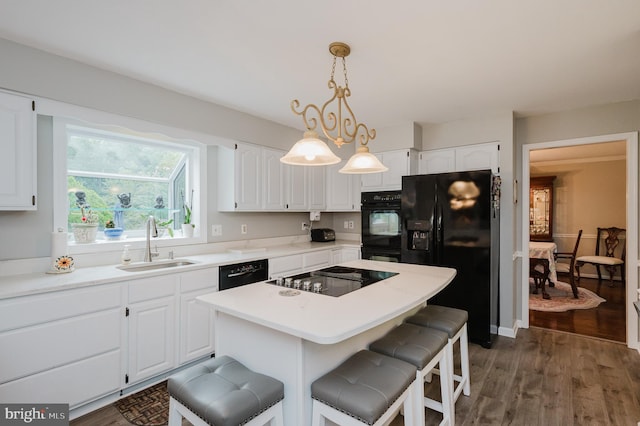 kitchen with black appliances, a sink, and white cabinetry