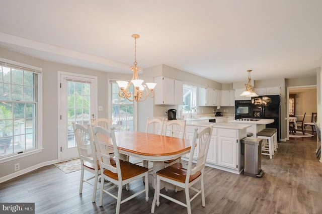 dining area with light wood finished floors, baseboards, and a chandelier