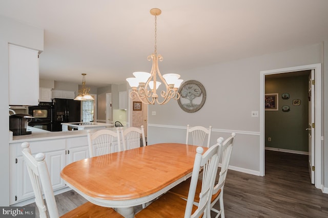 dining area featuring dark wood-style floors, a chandelier, and baseboards