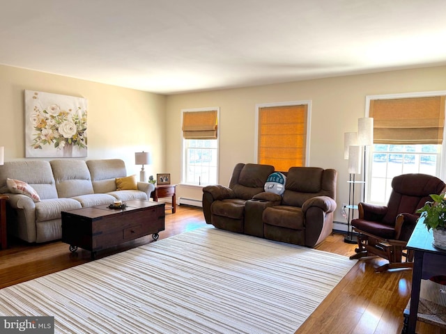 living room featuring light wood finished floors and a baseboard heating unit