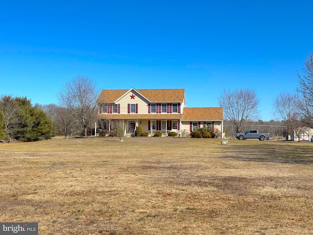 traditional-style house with covered porch and a front lawn