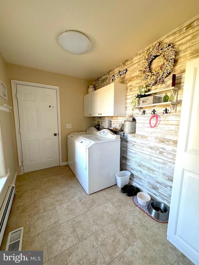 laundry room with a baseboard heating unit, cabinet space, visible vents, and separate washer and dryer