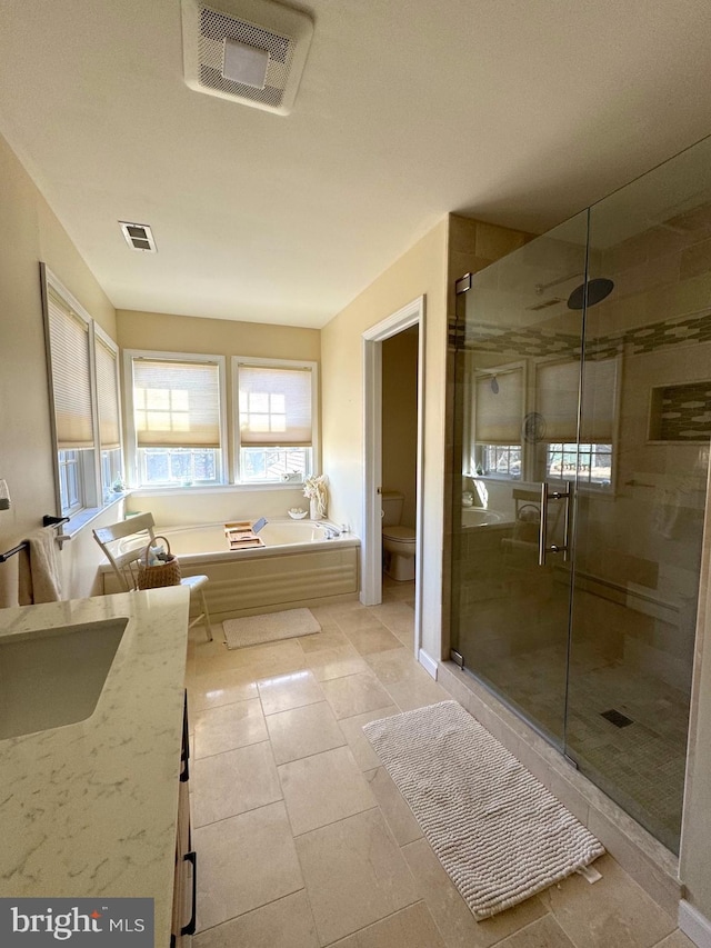 full bathroom with toilet, a shower stall, and visible vents