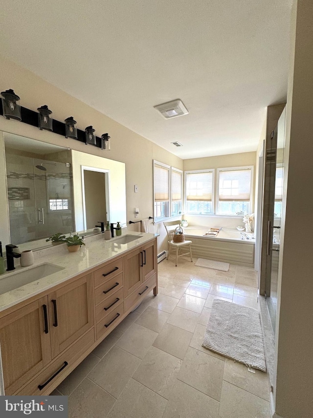 bathroom featuring double vanity, a garden tub, a shower stall, and a sink