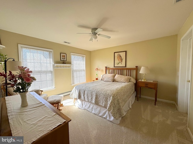 carpeted bedroom featuring a baseboard heating unit, visible vents, baseboards, and a ceiling fan