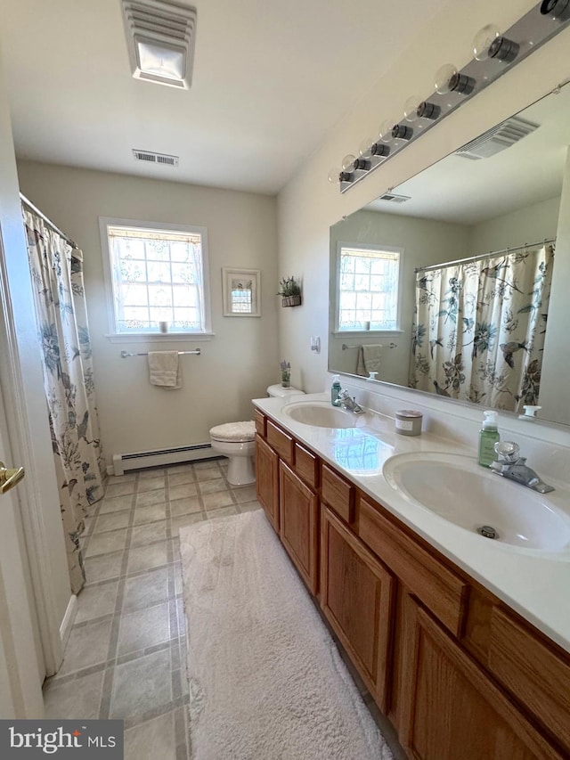 full bathroom with baseboard heating, a sink, and visible vents