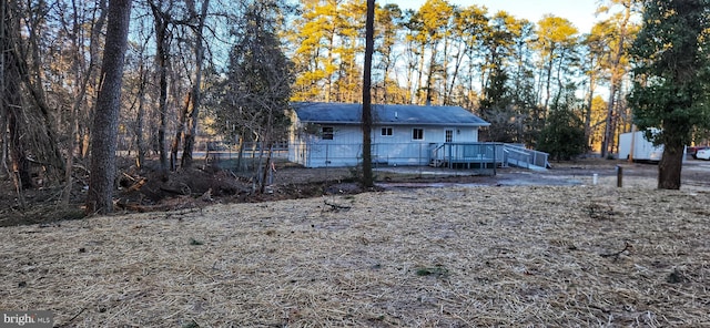 back of property with fence and a wooden deck