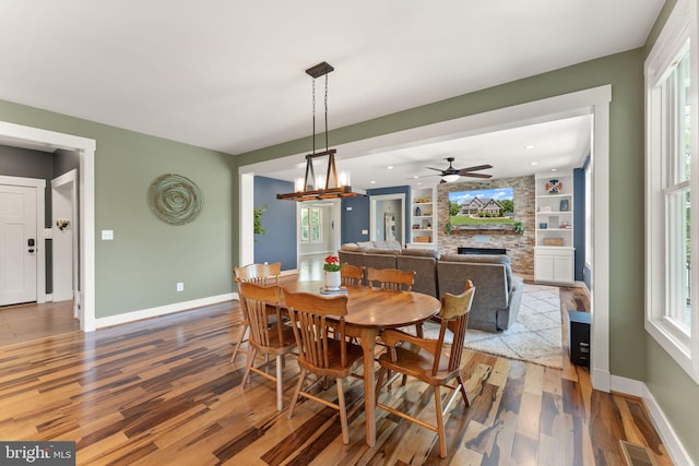 36976 Walnut Park Ln, Purcellville, VA 20132 - dining area featuring wood finished floors, baseboards, a stone fireplace, and healthy amount of natural light
