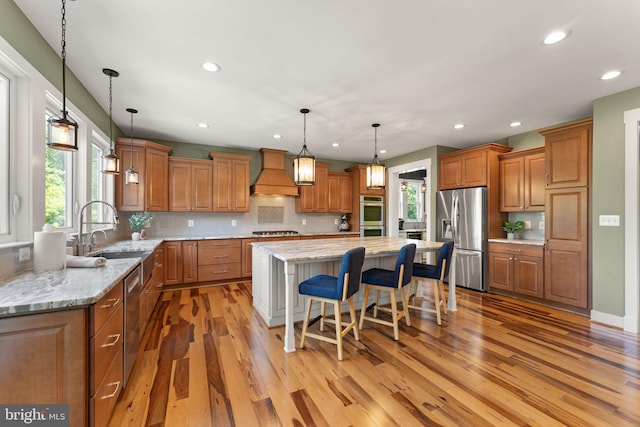 36976 Walnut Park Ln, Purcellville, VA 20132 - kitchen featuring appliances with stainless steel finishes, custom exhaust hood, brown cabinetry, and recessed lighting