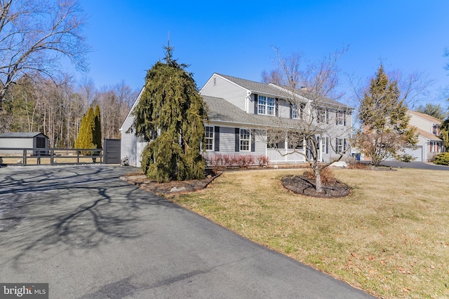 view of front of property featuring a gate, aphalt driveway, a front yard, and fence