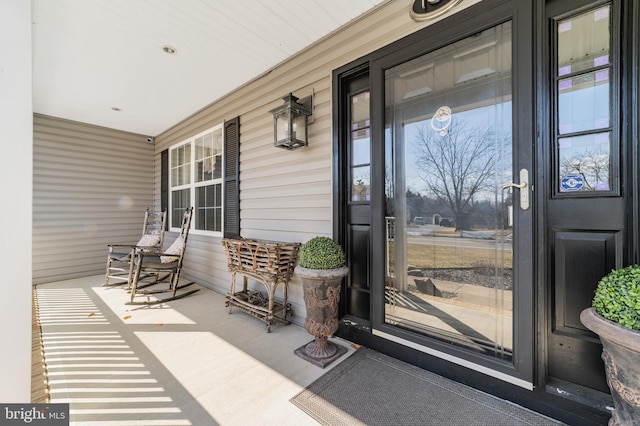 view of exterior entry featuring covered porch