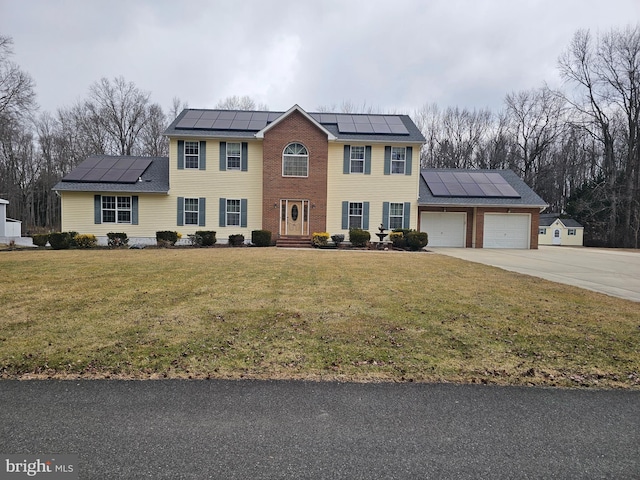 view of front facade featuring concrete driveway, a front lawn, an attached garage, and roof mounted solar panels