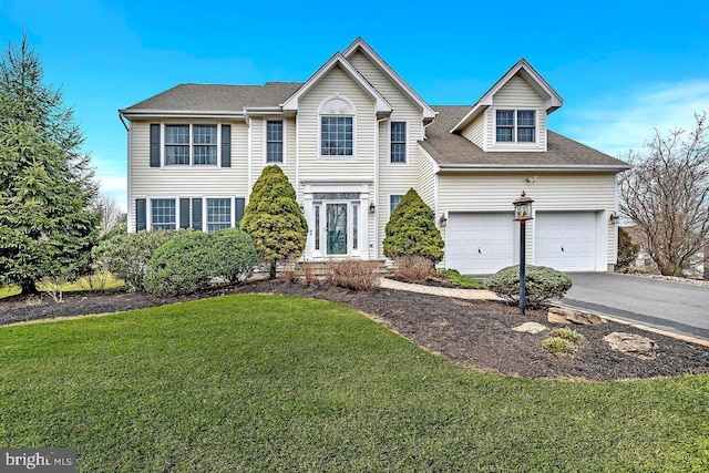 view of front of property featuring a garage, aphalt driveway, and a front yard