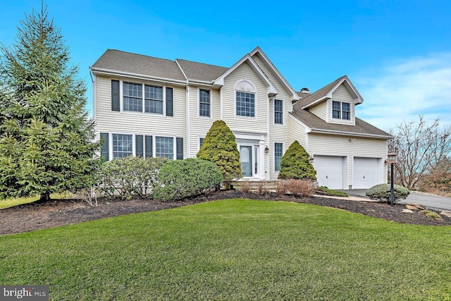 view of front of home with driveway, a garage, and a front lawn