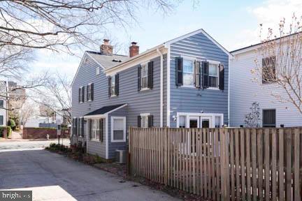 view of side of home with a chimney and fence