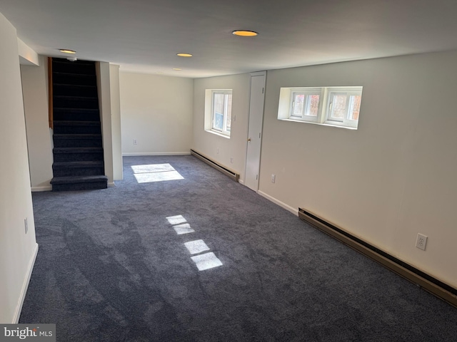 interior space featuring a baseboard radiator, a baseboard heating unit, baseboards, stairway, and dark colored carpet