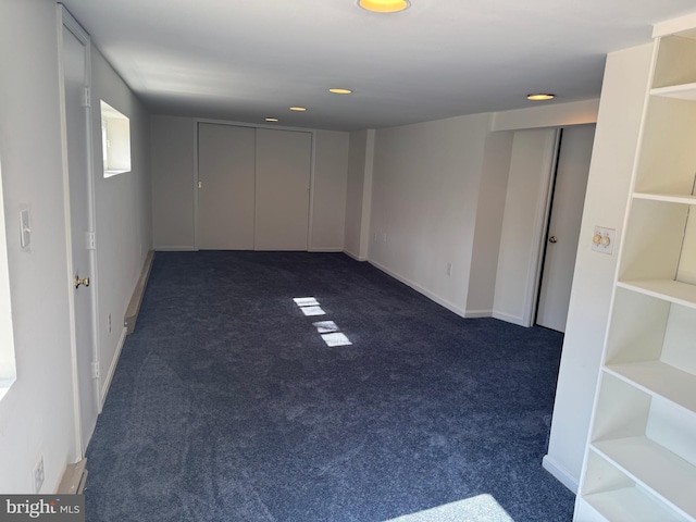 below grade area with baseboards, dark carpet, and recessed lighting