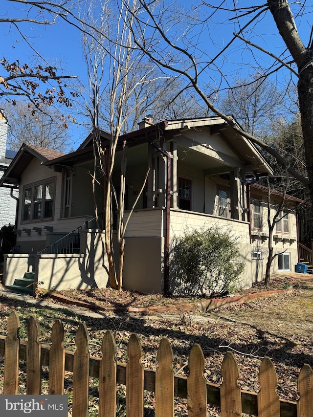 view of property exterior featuring a fenced front yard and a chimney