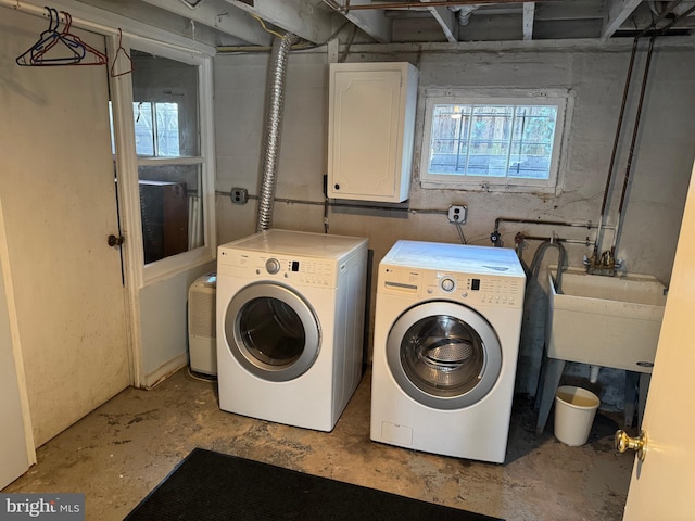 laundry room featuring laundry area, washing machine and dryer, and a sink