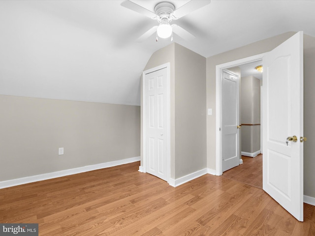 additional living space with light wood-type flooring, baseboards, vaulted ceiling, and a ceiling fan