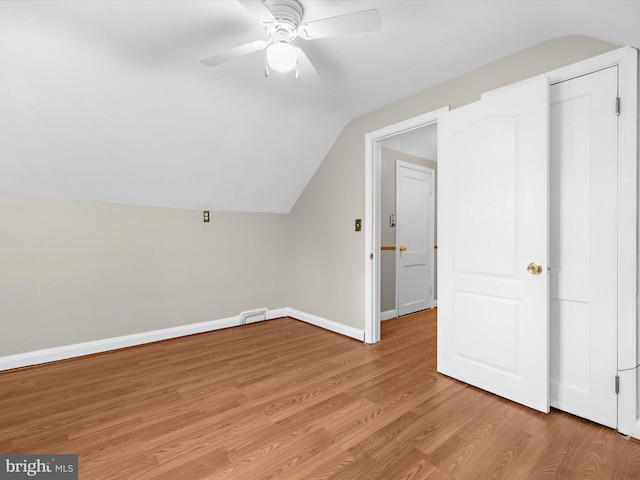 additional living space featuring lofted ceiling, ceiling fan, light wood-style flooring, and baseboards