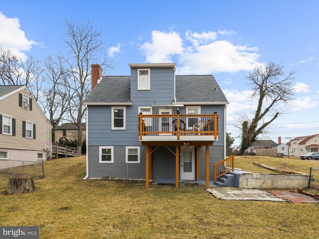 back of house with a yard, a chimney, a wooden deck, and fence