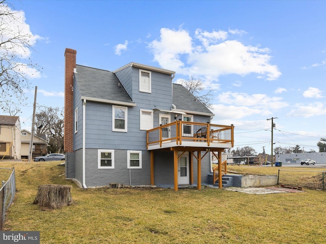 rear view of property with a chimney, fence, a lawn, and a wooden deck