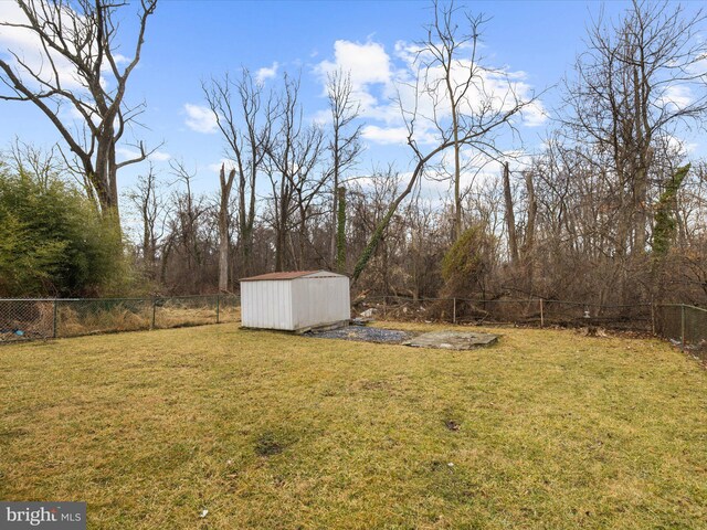 view of yard featuring a shed, an outdoor structure, and a fenced backyard