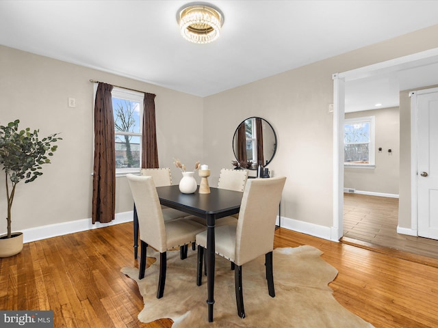 dining space with hardwood / wood-style flooring and baseboards