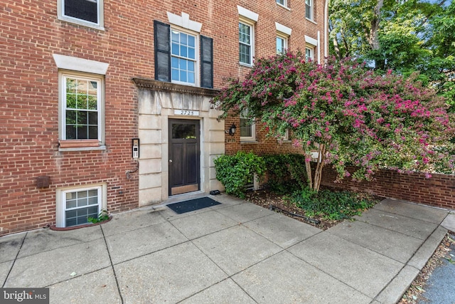 view of exterior entry featuring brick siding