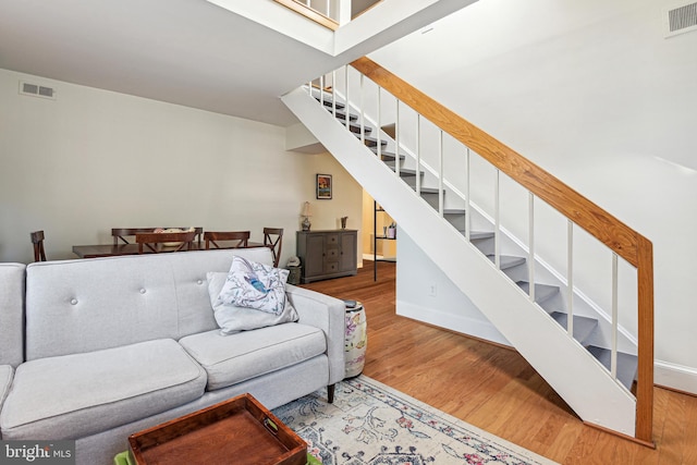 living area featuring stairway, wood finished floors, and visible vents