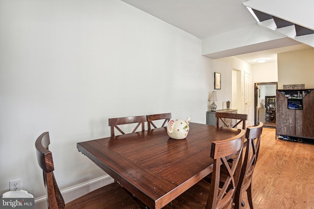 dining room with light wood-type flooring and baseboards