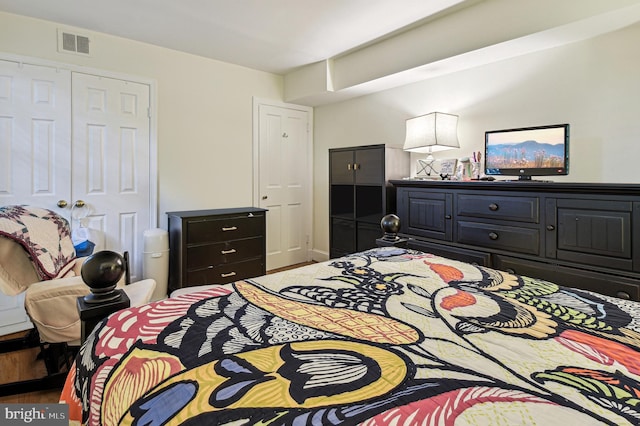 bedroom featuring a closet, wood finished floors, and visible vents