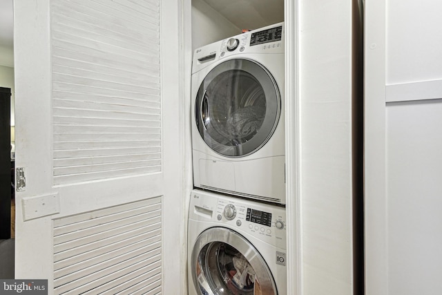 clothes washing area with stacked washer and dryer and laundry area