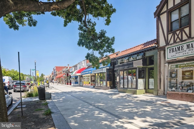 view of road featuring street lights, curbs, and sidewalks