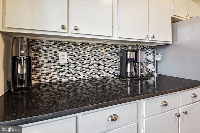 kitchen with dark stone countertops, white cabinets, and decorative backsplash