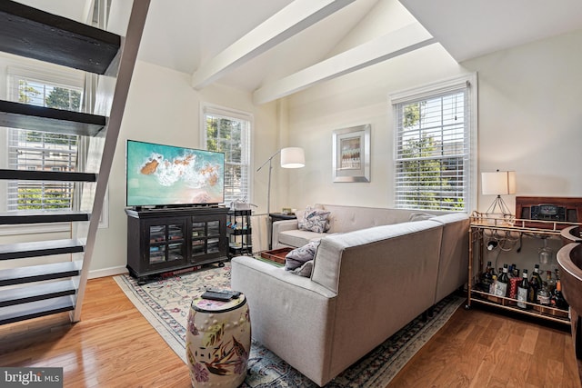 living room with vaulted ceiling with beams and wood finished floors