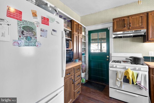 kitchen with under cabinet range hood, white appliances, light countertops, dark wood-style floors, and brown cabinetry