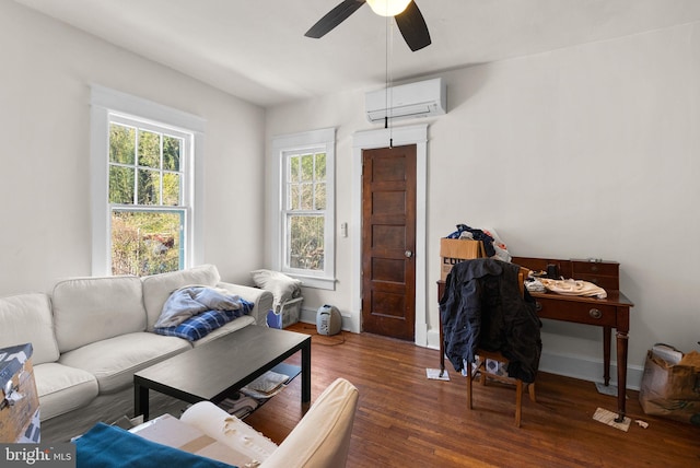 living area featuring dark wood-style flooring, ceiling fan, an AC wall unit, and baseboards