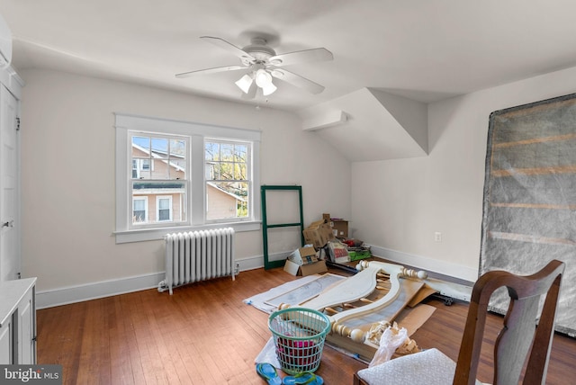 additional living space featuring ceiling fan, wood finished floors, baseboards, vaulted ceiling, and radiator heating unit