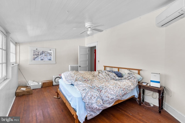 bedroom featuring dark wood finished floors, lofted ceiling, radiator heating unit, an AC wall unit, and ceiling fan