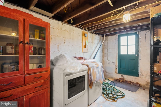 clothes washing area featuring laundry area and washer and clothes dryer