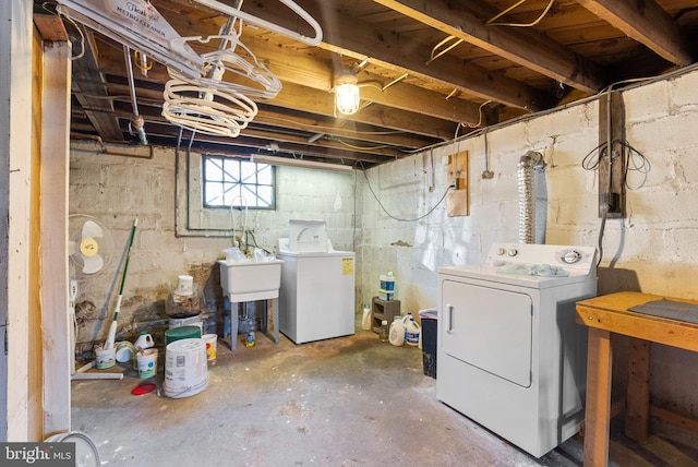 basement featuring separate washer and dryer and a sink