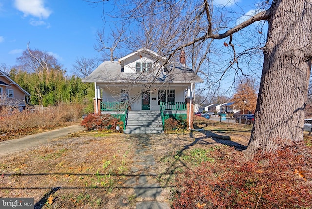 bungalow with covered porch and a chimney