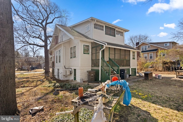 rear view of house featuring a sunroom